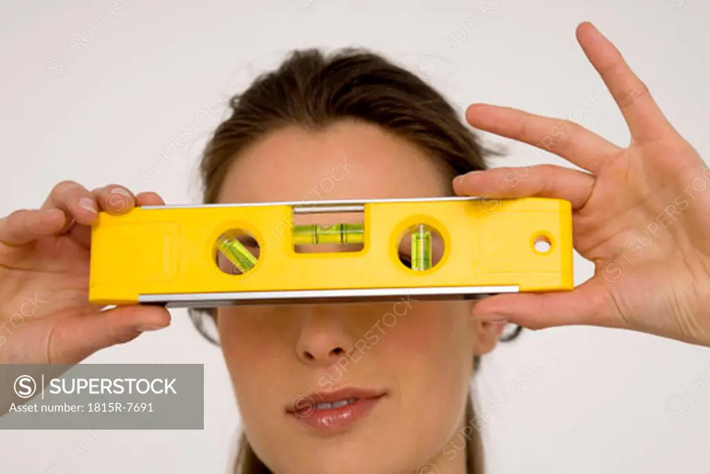 Young woman holding spirit level, close-up