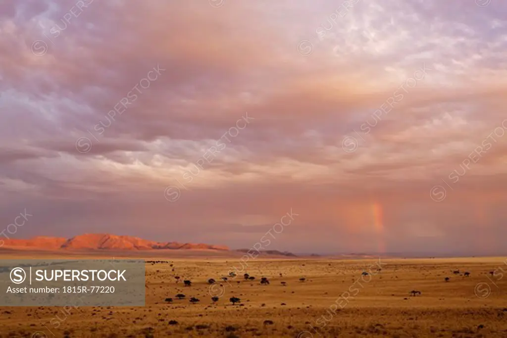 Africa, Namibia, Namib Desert, View of rainbow over gondwana sperrgebiet rand park at dusk