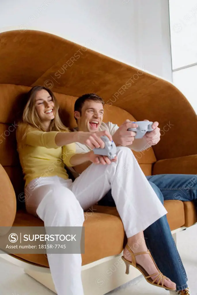 Young couple playing video game, low angle view