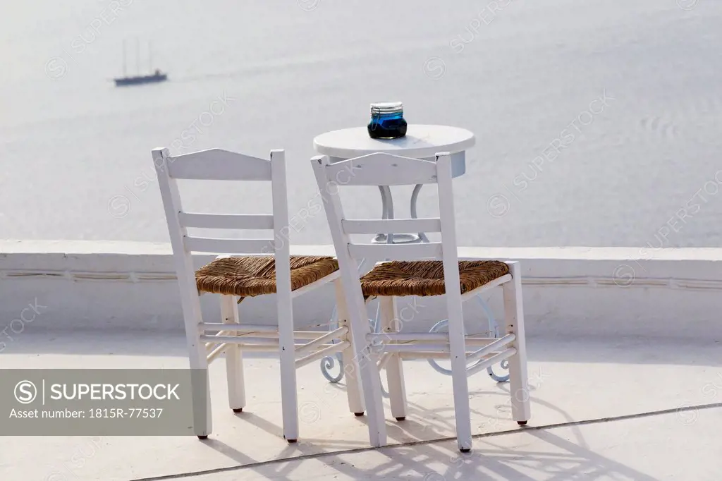 Greece, Cyclades, Thira, Santorini, Firostefani, Table and chairs with view of the caldera