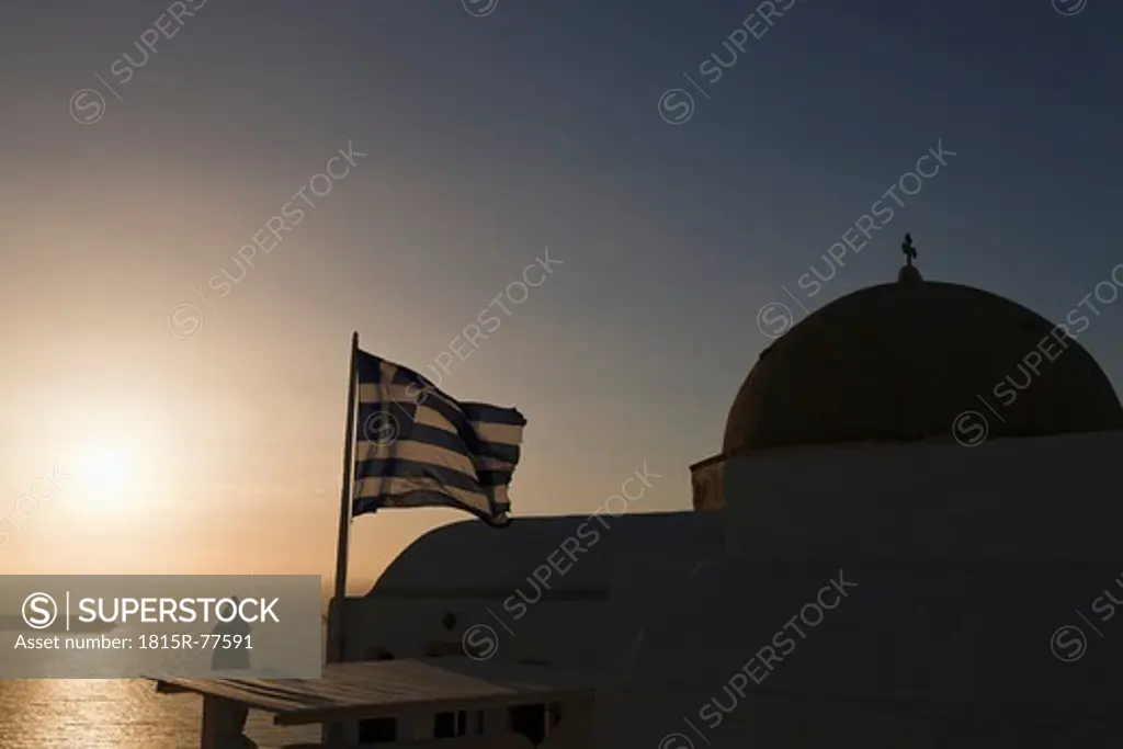 Europe, Greece, Aegean Sea, Cyclades, Thira, Santorini, Oia, Greek flag beside the cupola of a churc