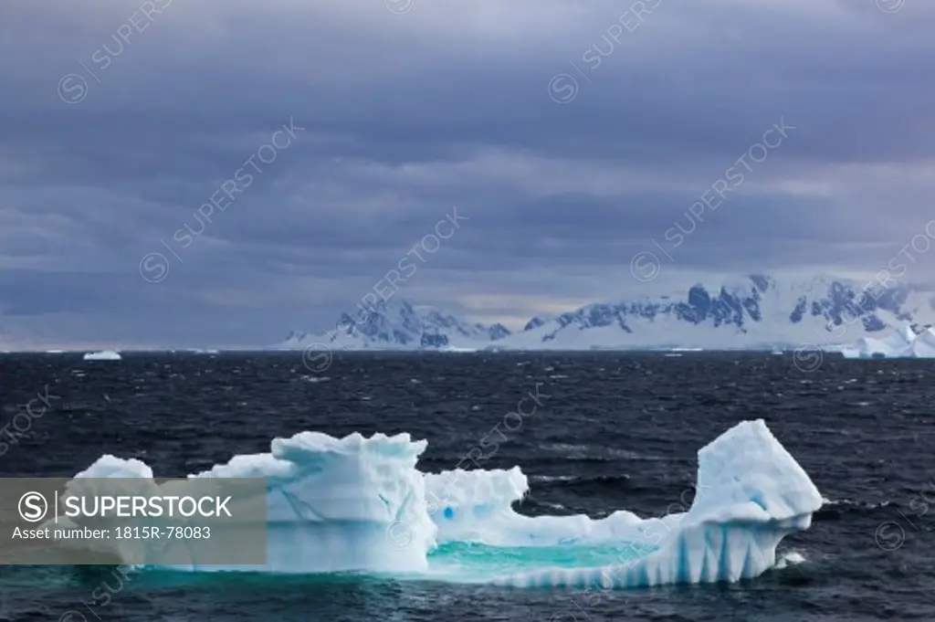 South Atlantic Ocean, Antarctica, Antarctic Peninsula, Gerlache Strait, View of iceberg with snow_covered mountain range
