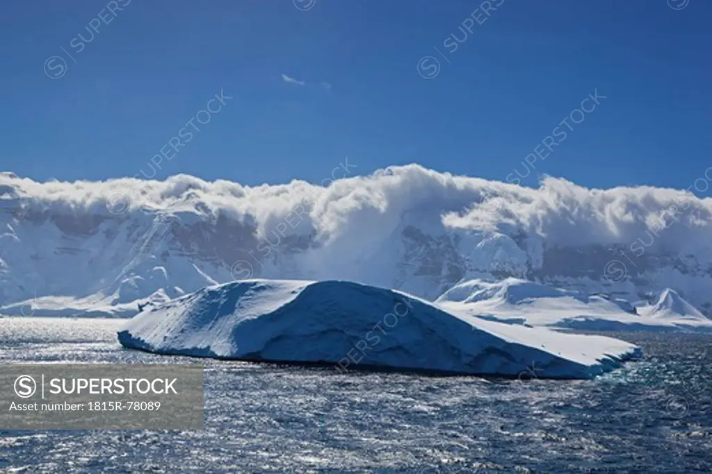 South Atlantic Ocean, Antarctica, Antarctic Peninsula, Gerlache Strait, View of iceberg with snow_covered mountain range