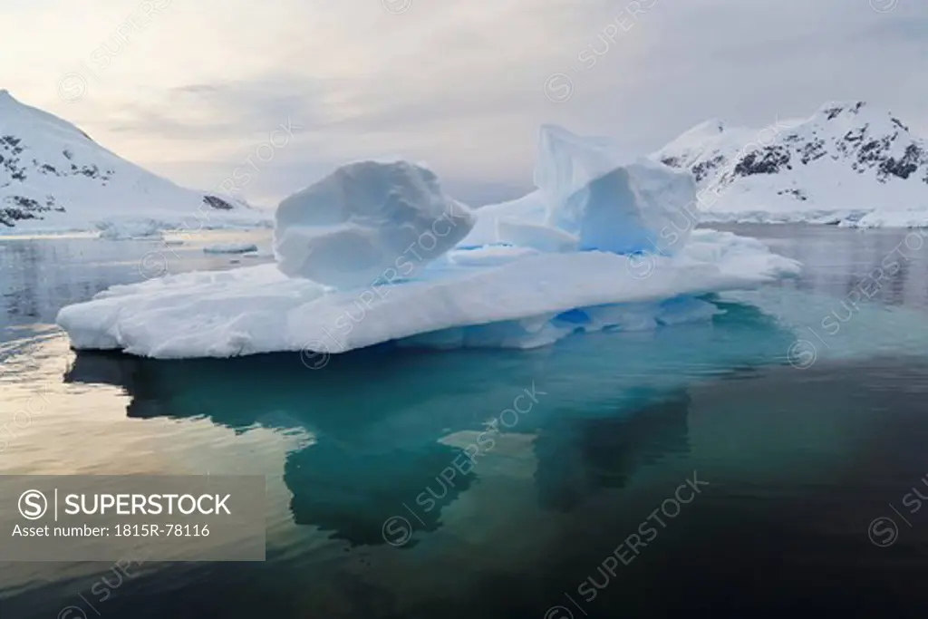 South Atlantic Ocean, Antarctica, Antarctic Peninsula, Gerlache Strait, Blue iceberg and Snow coverd mountain range at paradise bay