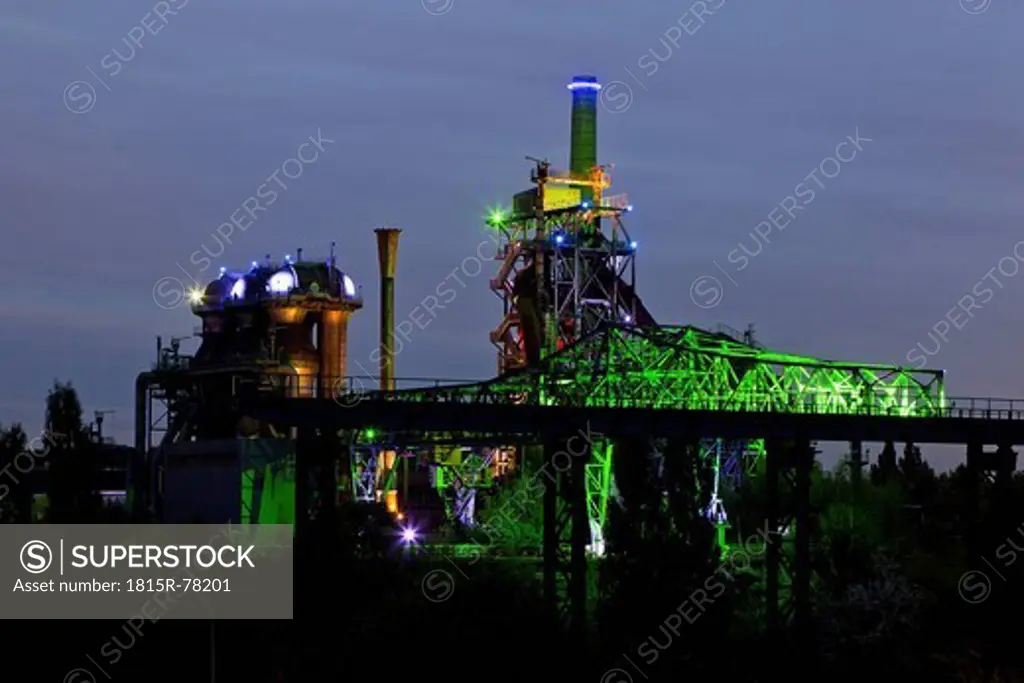 Germany, Nordrhein_Westfalen, Duisburg, Duisburg_Nord Landscape Park, View of illuminated blast furnace and smoke stacks of old industrial plant