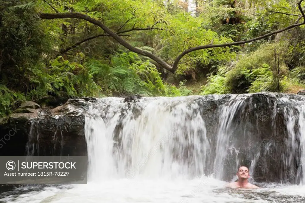 New Zealand, North Island, Mature man taking a bath in hot spring kerosin creekNew Zealand, North Island, Mature man taking a bath in hot spring kerosin creek