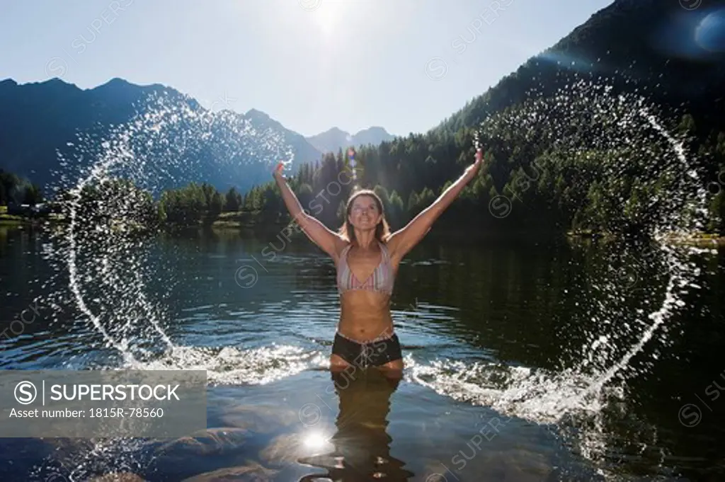Austria, Styria, Mid adult woman standing in lake duisitzkar at schladming