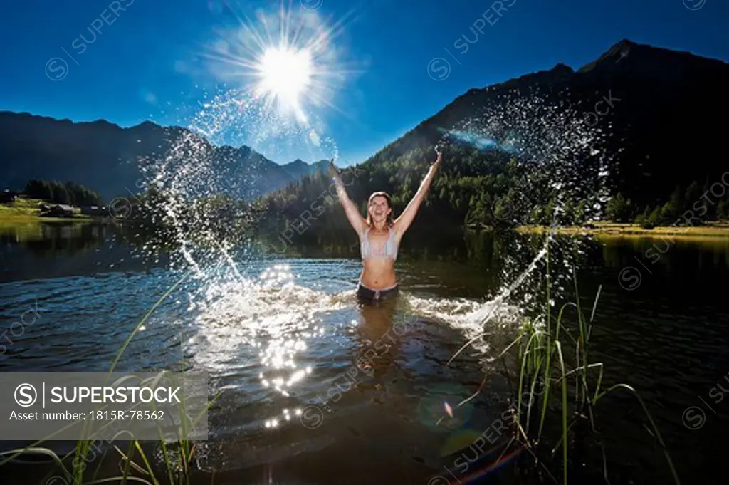 Austria, Styria, Mid adult woman standing in lake duisitzkar at schladming