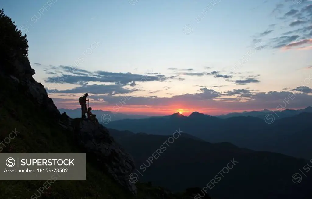 Austria, Salzburg Country, Altenmarkt_Zauchensee, Couple watching sunrise on mountains of Niedere Tauern