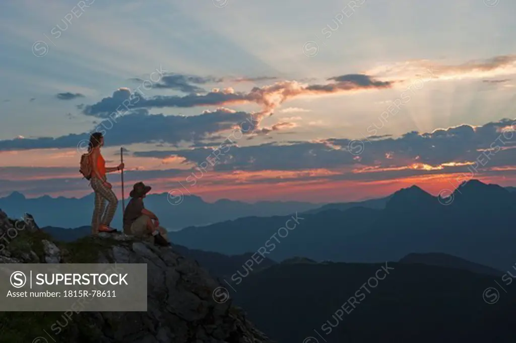 Austria, Salzburg Country, Altenmarkt_Zauchensee, Couple watching sunrise on mountains of Niedere Tauern