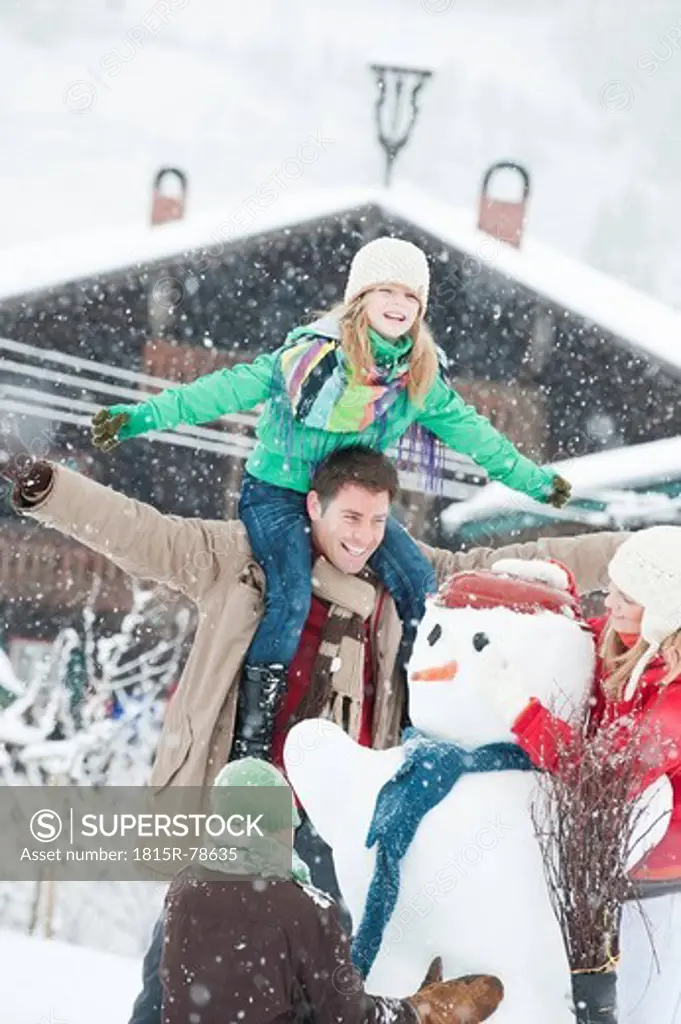 Austria, Salzburg, Hüttau, Family preparing snowman