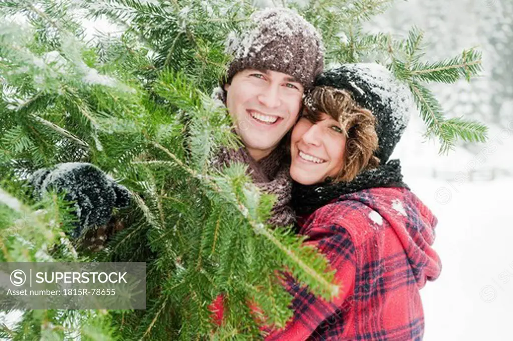 Austria, Salzburg Country, Flachau, Young man and woman holding christmas tree