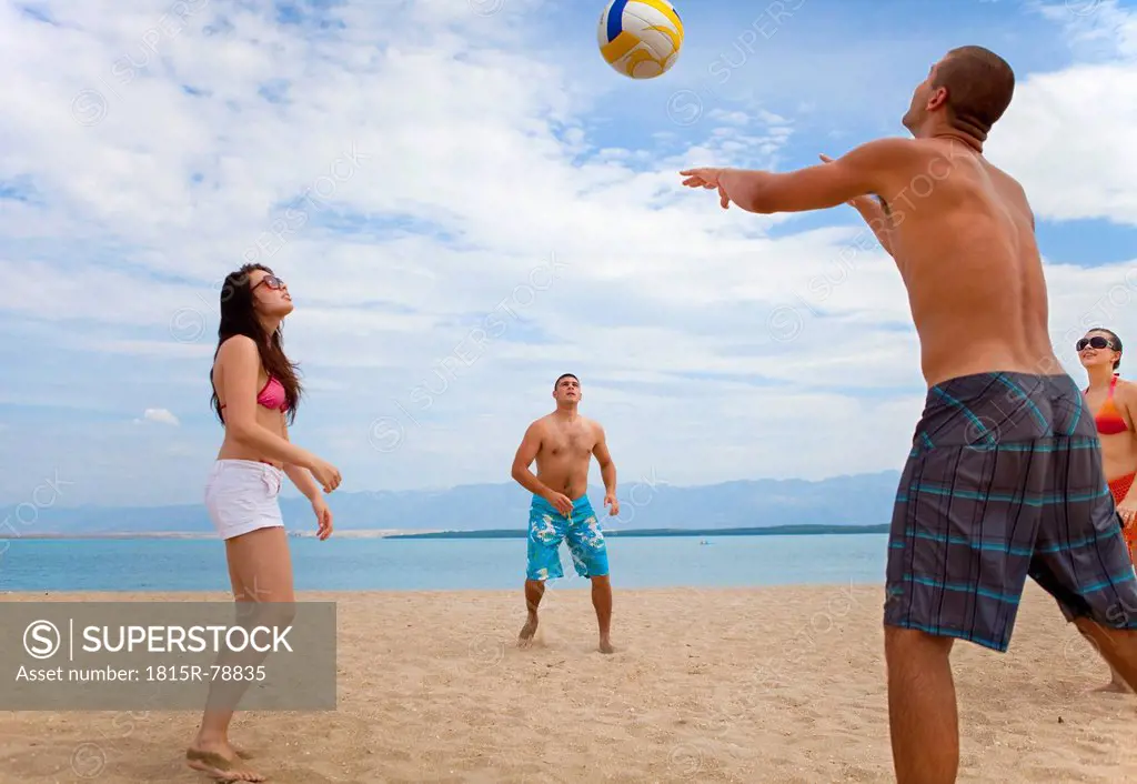 Croatia, Zadar, Friends playing volley ball at beach
