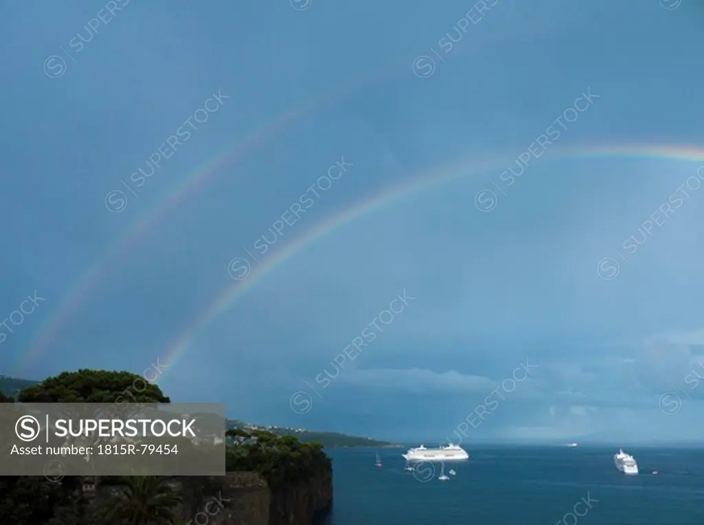 Southern Italy, Amalfi Coast, Piano di Sorrento, View of rainbow and ship in sea with cliff in foreground
