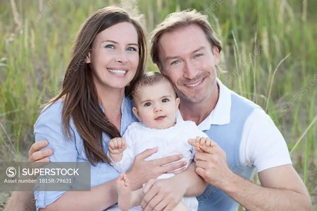Germany, Bavaria, Mother and father with 2_5 months baby girl, smiling