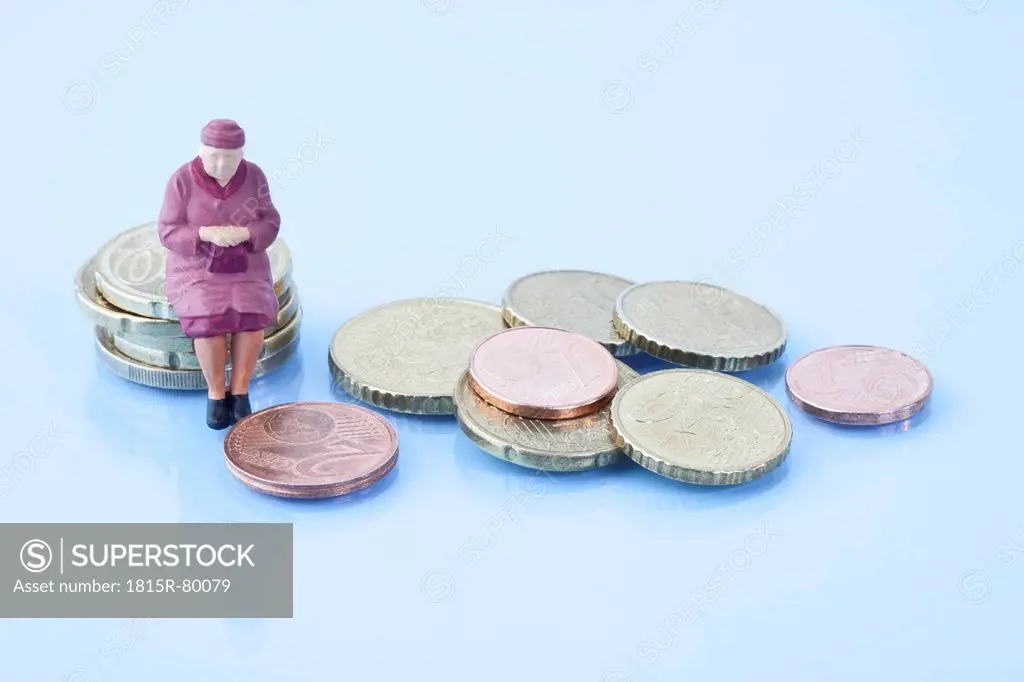 Female figurine sitting on stack of euro coins