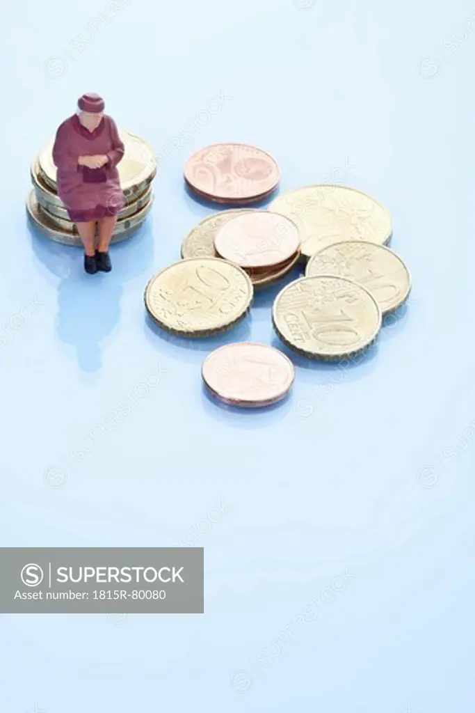 Female figurine sitting on stack of euro coins