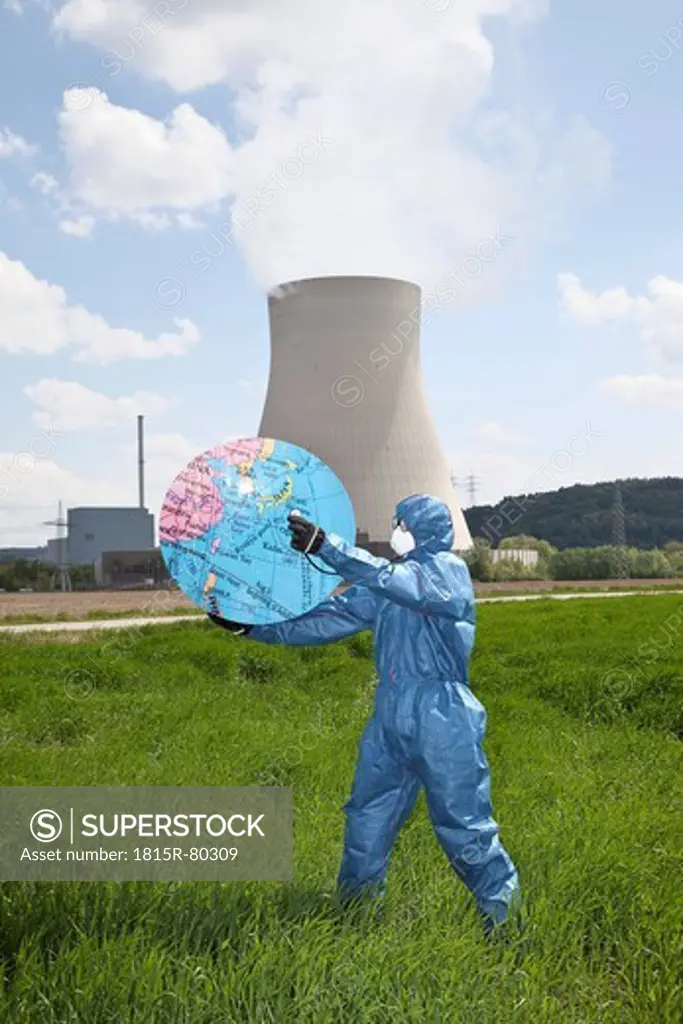 Germany, Bavaria, Man in protective workwear holding globe at AKW Isar