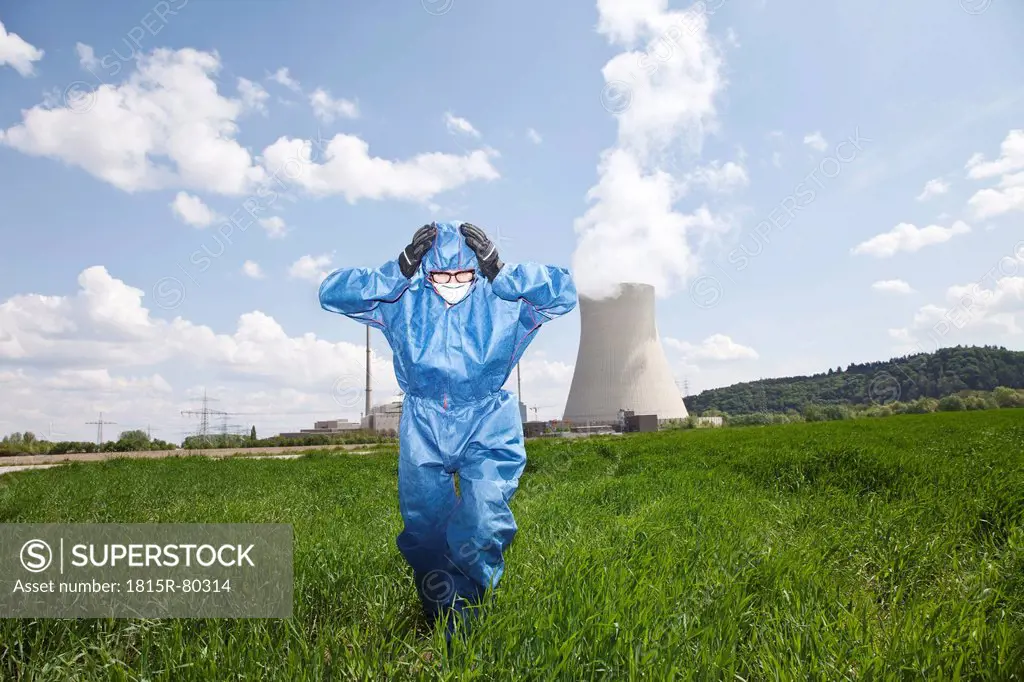 Germany, Bavaria, Unterahrain, Man with protective workwear walking in field at AKW Isar