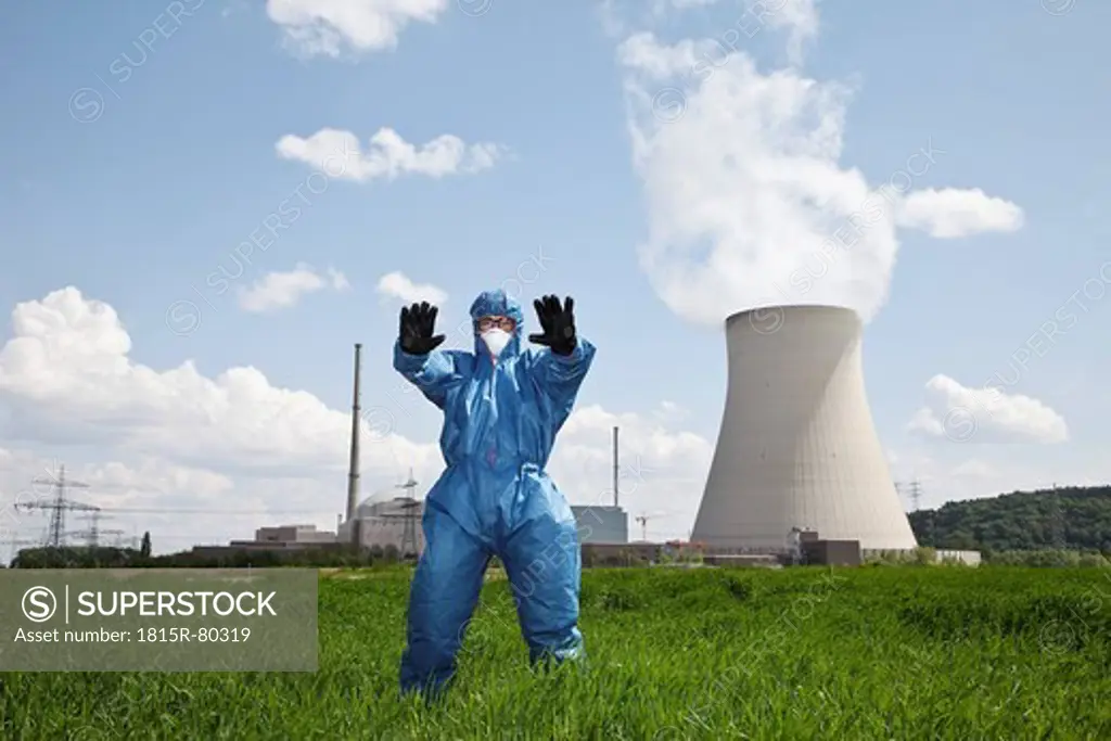 Germany, Bavaria, Unterahrain, Man with protective workwear standing in field at AKW Isar