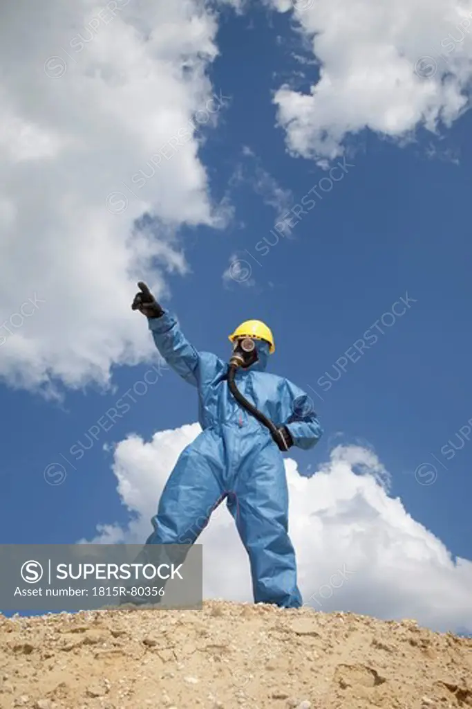 Germany, Bavaria, Man in protective workwear standing on top of sand dune