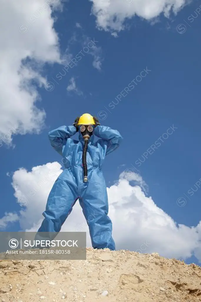 Germany, Bavaria, Man in protective workwear standing on top of sand dune