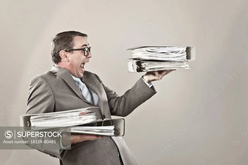 Close up of mature businessman at office holding stack of file