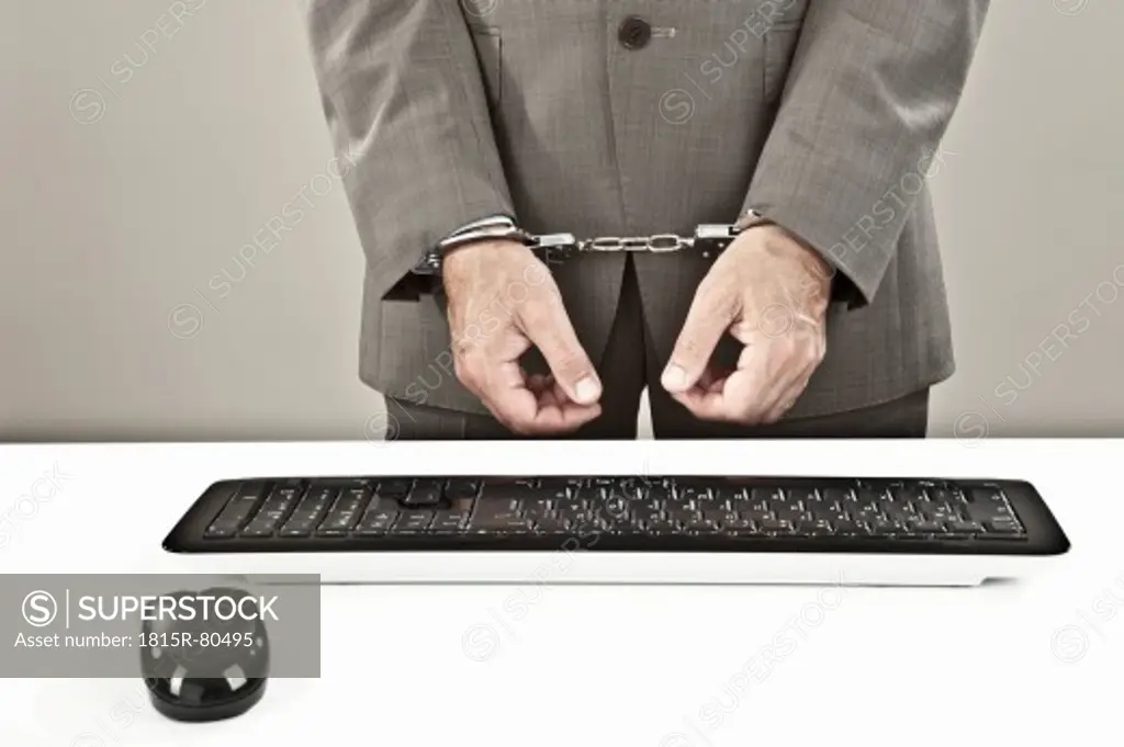 Close up of businessman standing near keyboard with hand´s cuffed