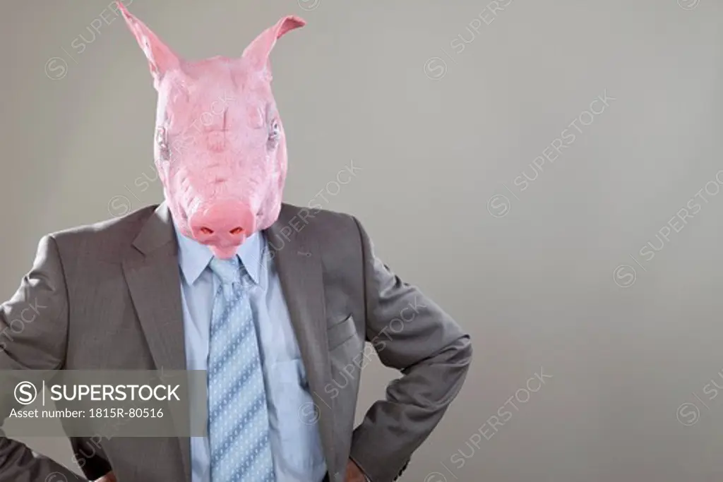Close up of businessman with pigs head in office against grey background