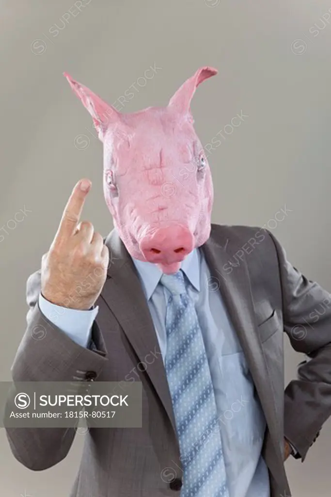 Close up of businessman with pigs head in office against grey background