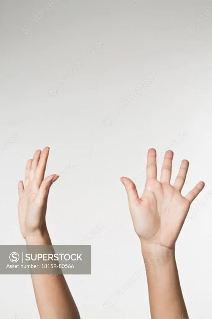 Woman raising hands against white background