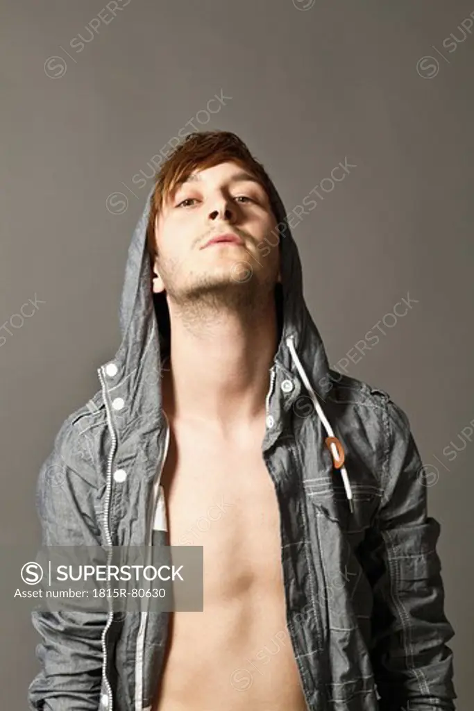 Close up of fashionable young man against grey background, portrait