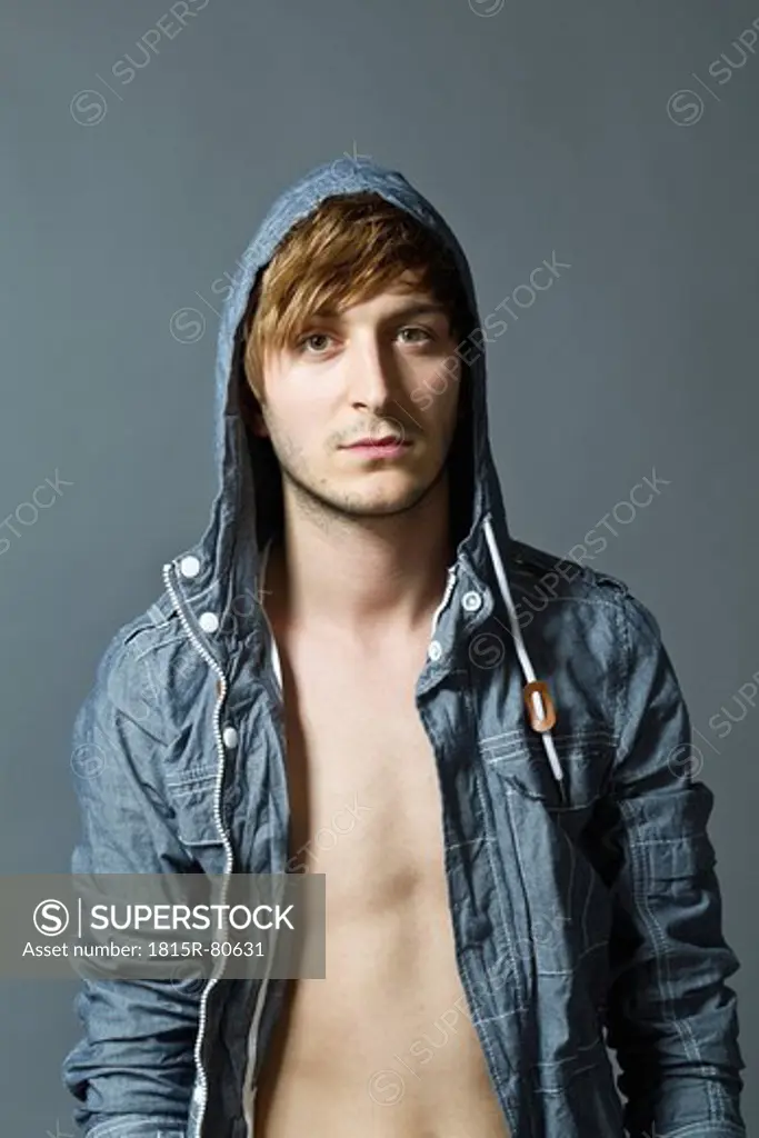 Close up of fashionable young man against grey background, portrait