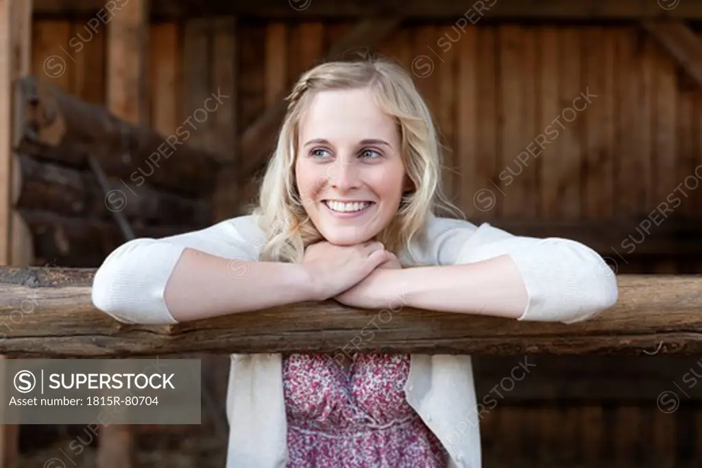 Germany, Saxony, Young woman looking away and smiling