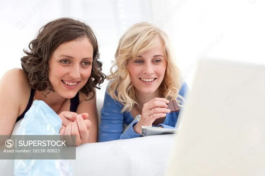 Germany, Leipzig, Young women watching a movie on laptop