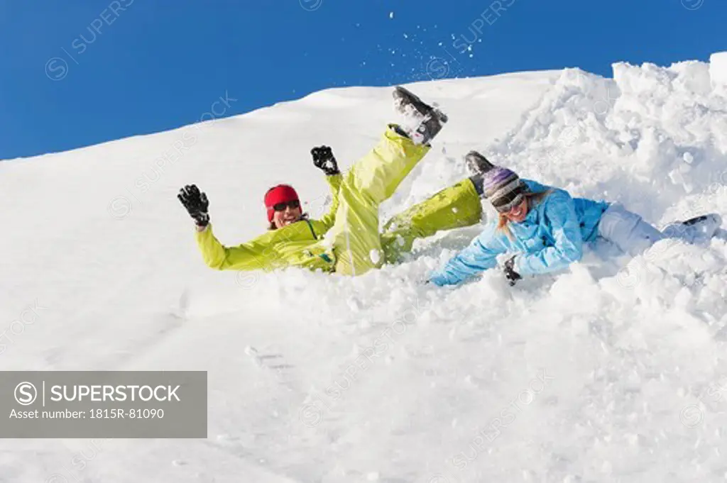 Italy, Trentino_Alto Adige, Alto Adige, Bolzano, Seiser Alm, Man and woman jumping on snow