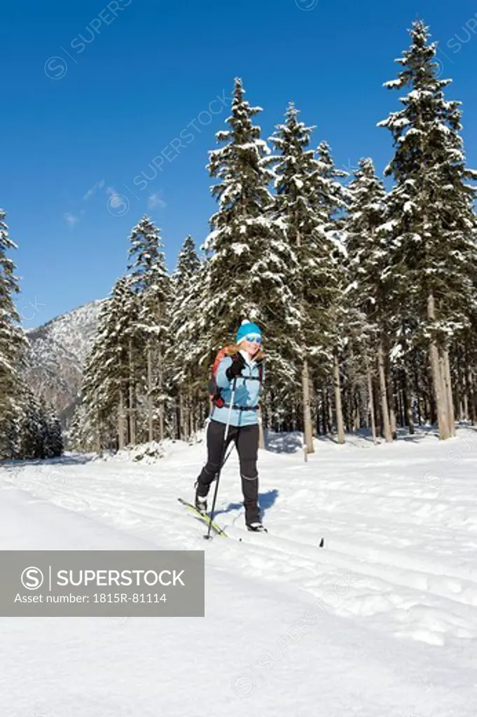 Germany, Bavaria, Senior woman doing cross_country skiing on winter landscape