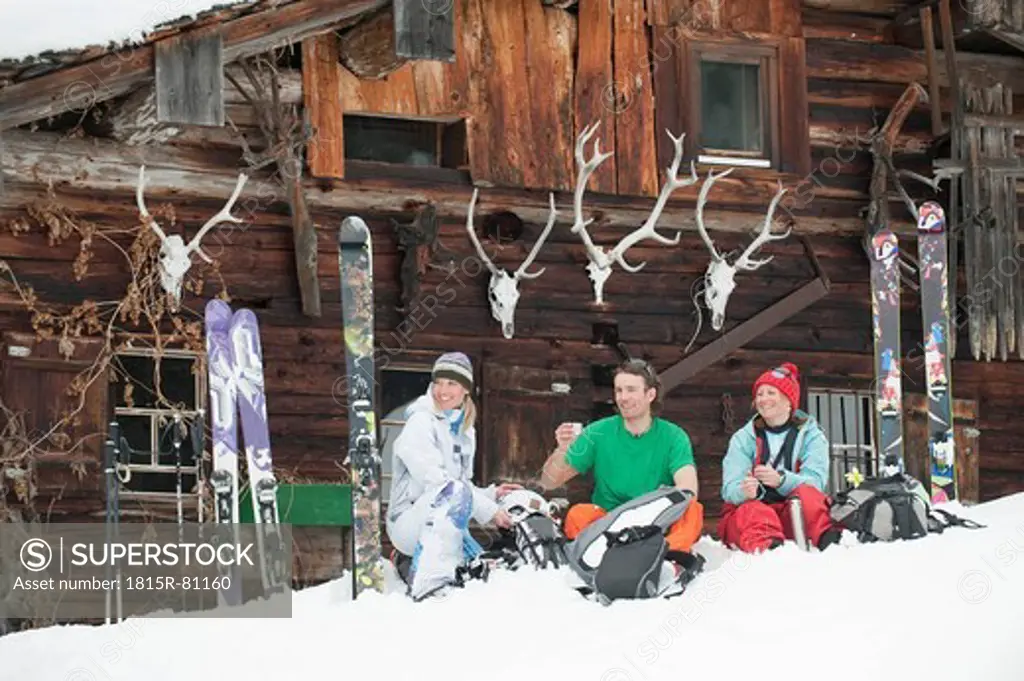 Austria, Kleinwalsertal, Friends sitting by mountain hut