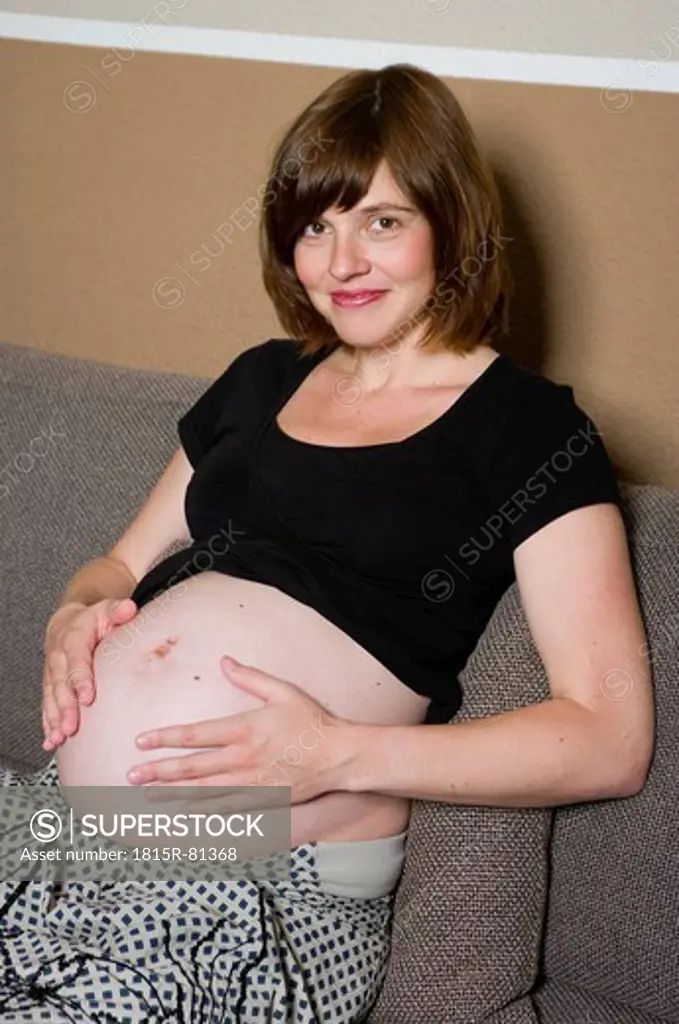 Germany, Hesse, Frankfurt, Pregnant woman smiling, portrait