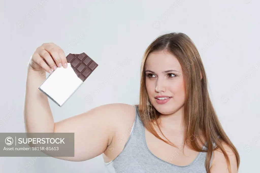 Young chubby woman with chocolate bar