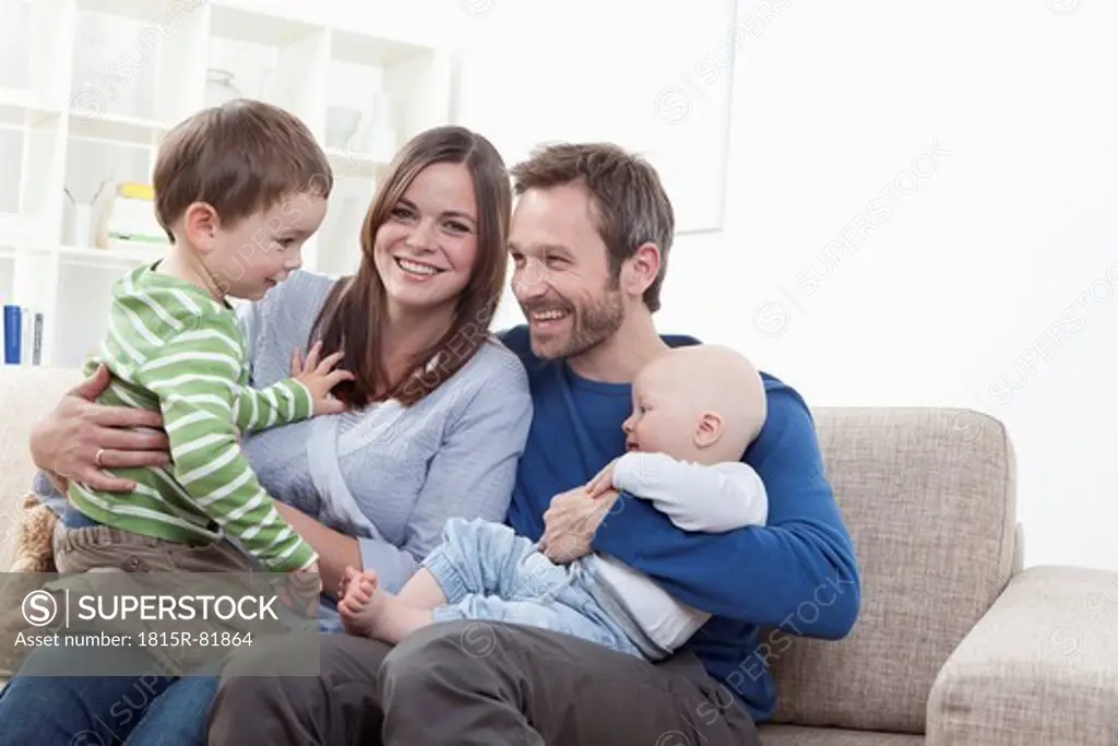 Germany, Bavaria, Munich, Family having fun in living room, smiling