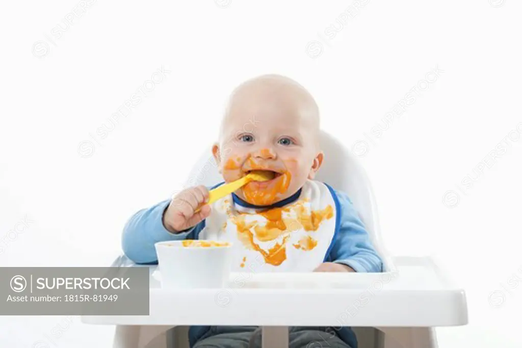 Baby boy 6_ 11 Months eating baby food with baby spoon