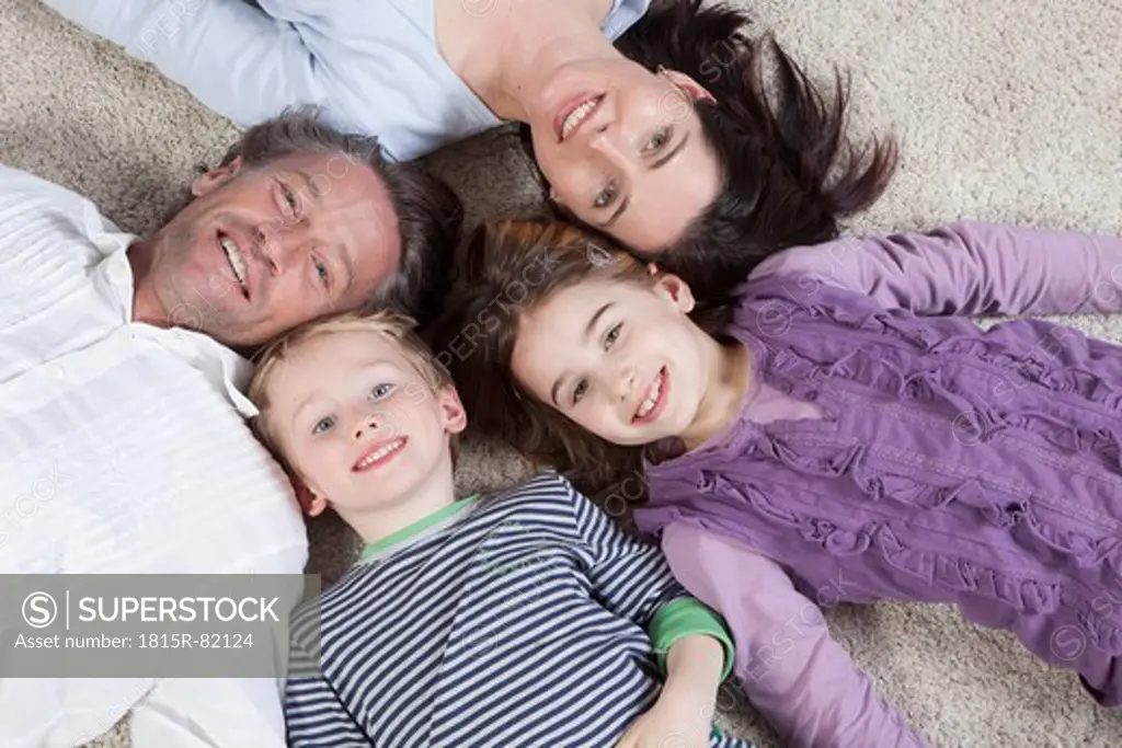 Germany, Bavaria, Munich, Family lying on floor, smiling