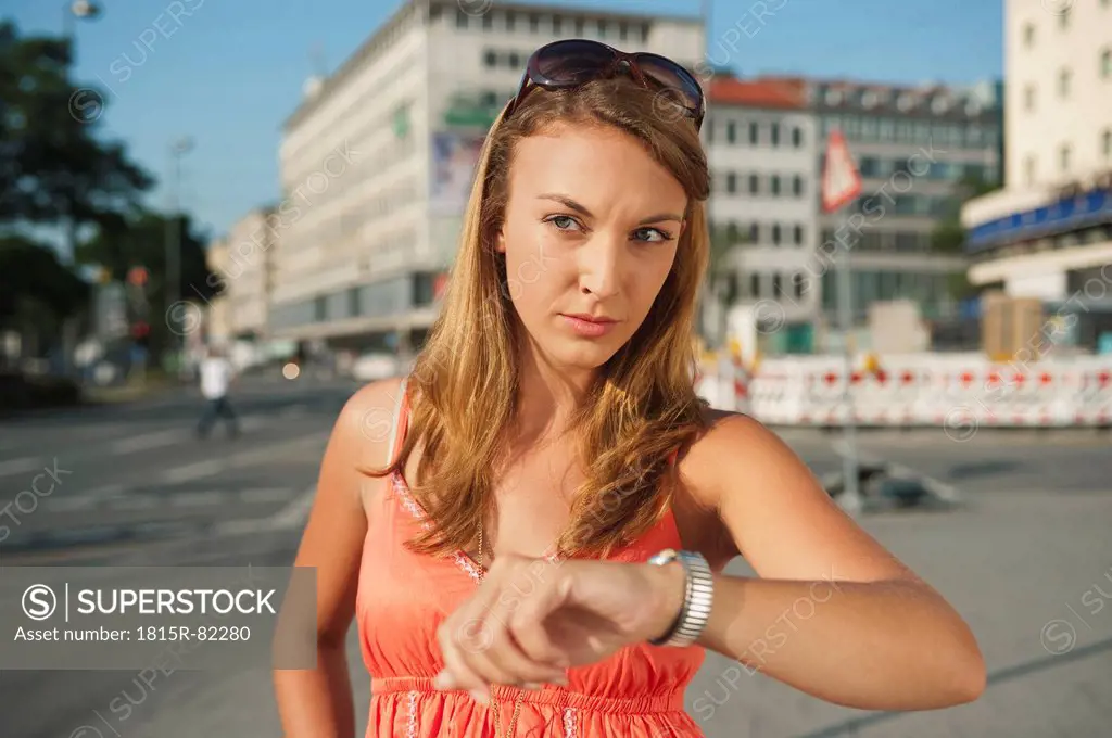 Germany, Munich, Karlsplatz, Young woman seriously looking away