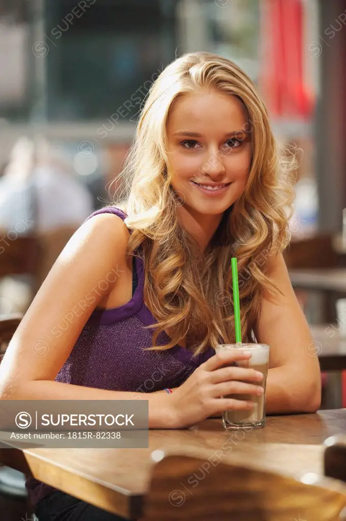 Germany, Munich, Teenage girl in cafe, smiling, portrait