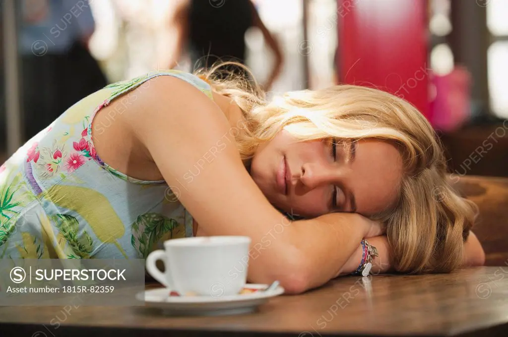 Germany, Munich, Teenage girl resting in cafe