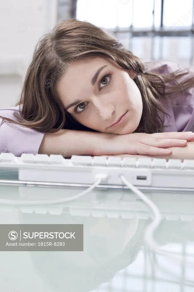Young businesswoman office, head resting on keypad