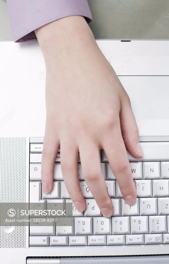 Woman typing on computer, one hand, elevated view