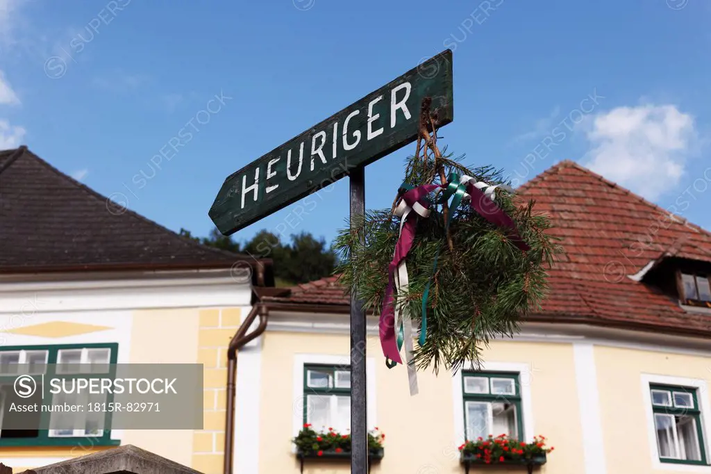 Austria, Lower Austria, Wachau, Waldviertel, Weissenkirchen, Text Heuriger on arrow sign with buildings