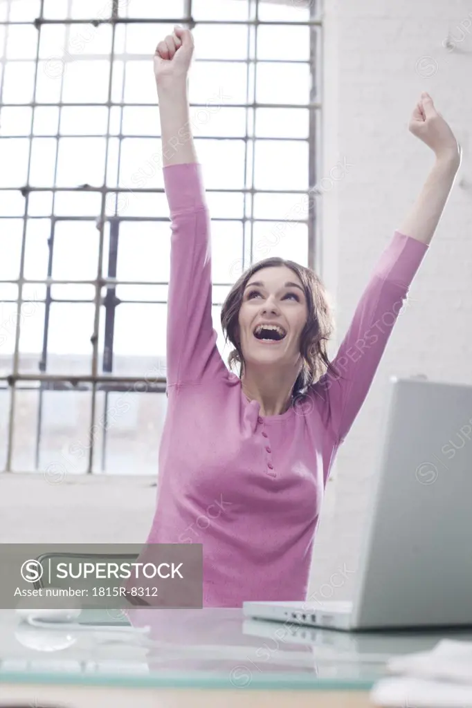 Young businesswoman in office, cheering